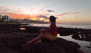 美女坐海边欣赏夕阳侧影视频素材