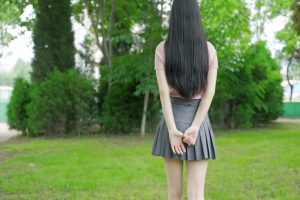 清纯的女孩子草地上行走的背影