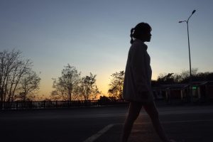 日落夕阳下女孩孤单伤感的行走在路上