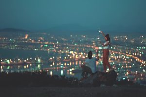 情侣在山顶游玩,山下灯火辉煌